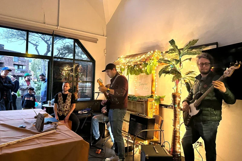 Team members playing live music with guitars at an office party